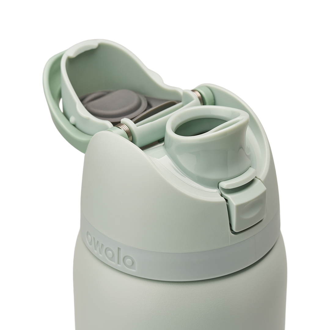 Owala FreeSip 32oz in Summer Paradise, lid detail with flip cap open exposing the FreeSip spout, mint green lid and flip cap with gray stainless steel spout interior visible